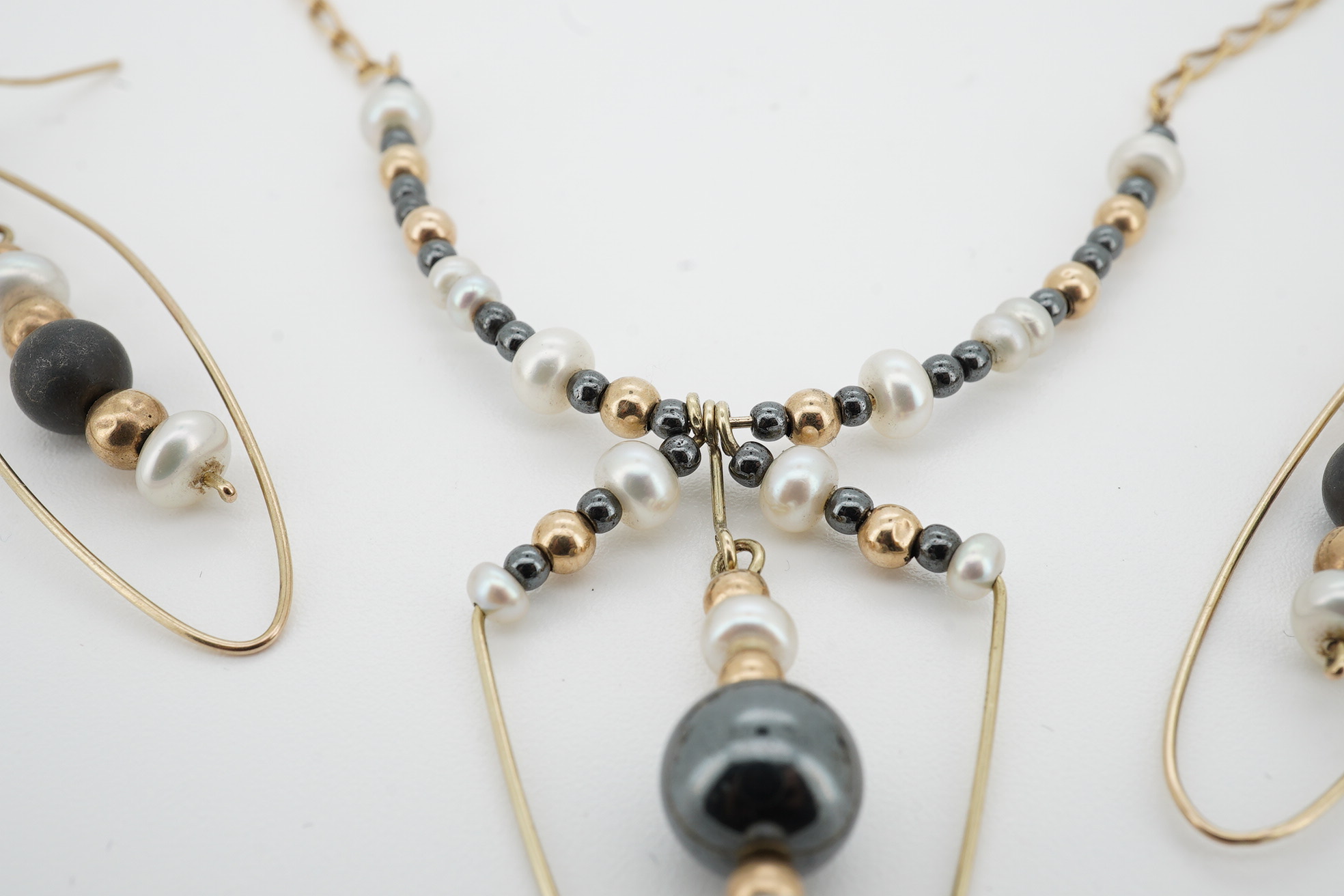 A modern Uno-A-Erre 9ct gold seed pearl and hematite cluster set necklace, approx. 40cm, with a pair of similar drop earrings, gross weight 10 grams. Condition - fair